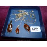 Five silver chains with three amber pendants with silver surround.