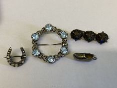 Two silver brooches including horseshoe and one with pale blue stones and a small clog charm plus