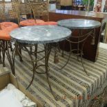 A pair of wrought iron and marble tables