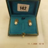 A pair of white pearl drop earrings with diamond bow tops