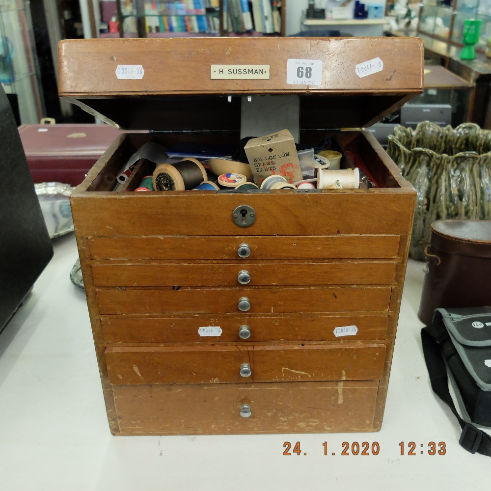 A flight of drawers with sewing related contents