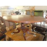 A Regency mahogany oval tilt top table on splayed base a.