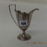 A late Victorian hallmarked silver helmet shaped pedestal cream jug,