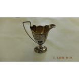 A late Victorian hallmarked silver helmet shaped pedestal cream jug,