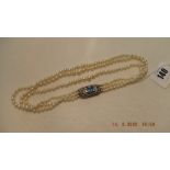 An art deco three row pearl necklace with fancy silver clasp