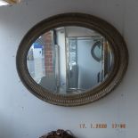 An oval gilt mirror