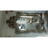 A decorative silver console table with mirror
