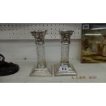 A pair of silver plated and crystal Corinthian column candlesticks