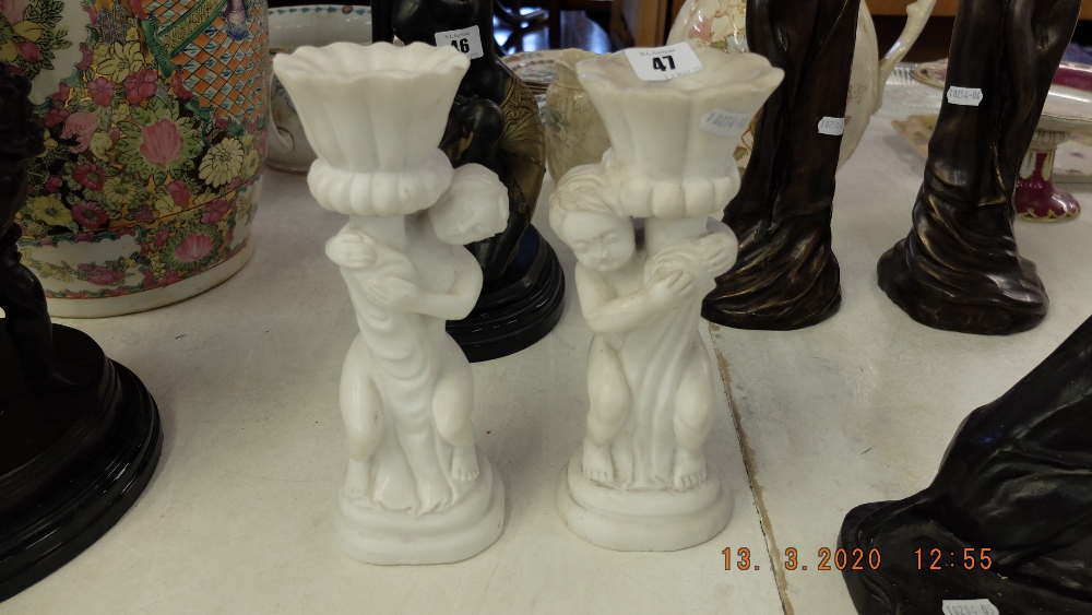 A pair of marble cherub candlesticks