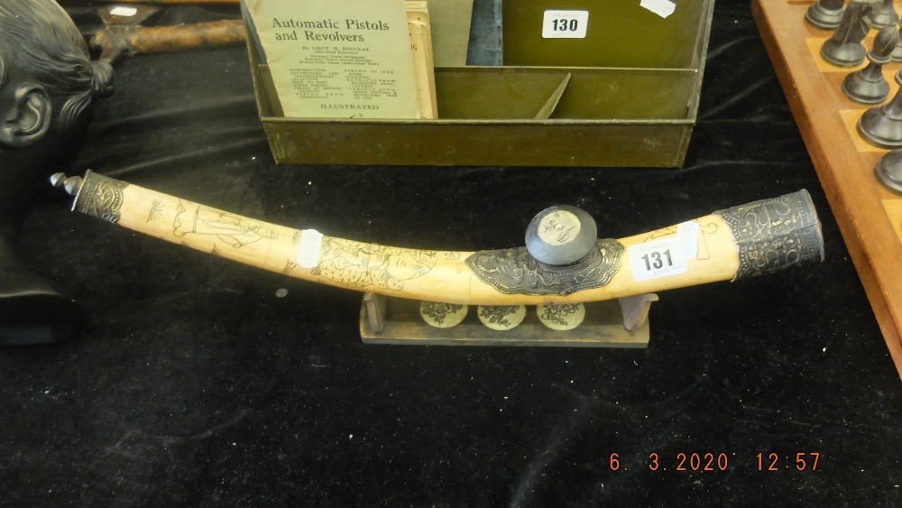 A vintage bone opium pipe on stand