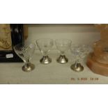 Four cut glass shot glasses with silver bases