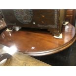 An oval tilt top dining table