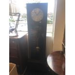 An art deco grandfather clock with pendulum weights and key
