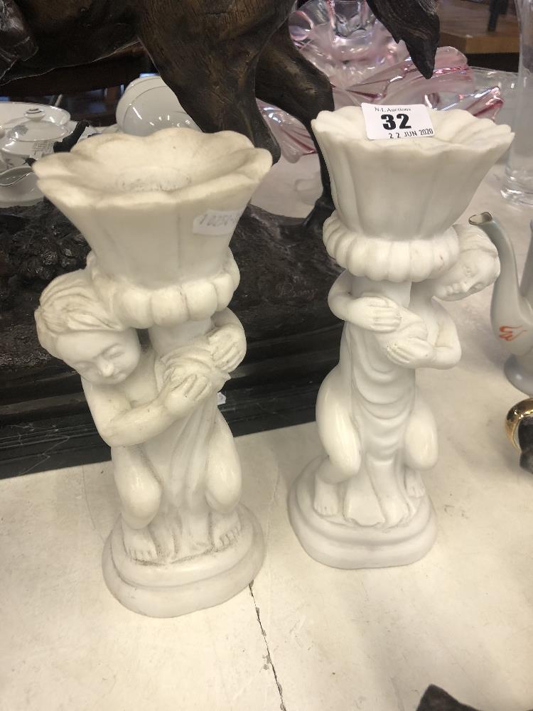 A pair of marble cherub candlesticks