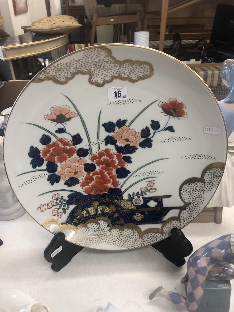 A decorative oriental charger on stand