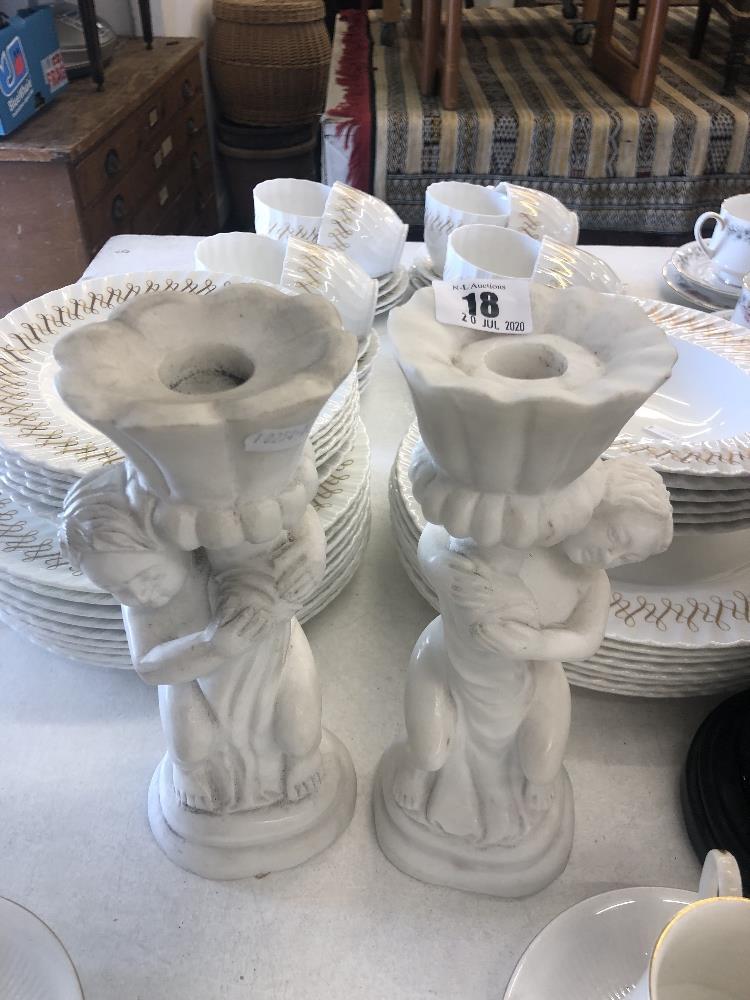 A pair of marble cherub candlesticks