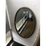 An oval gilt mirror