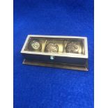 Three military buttons in a glass topped box