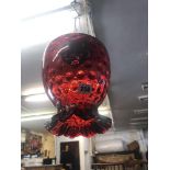 A cranberry glass hanging lamp shade