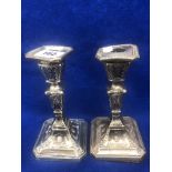 A pair of silver candlesticks, one a.