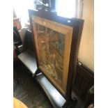 An oak framed needlework fire screen