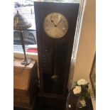 An art deco grandfather clock with pendulum weights and key