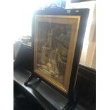 An oak framed needlework fire screen