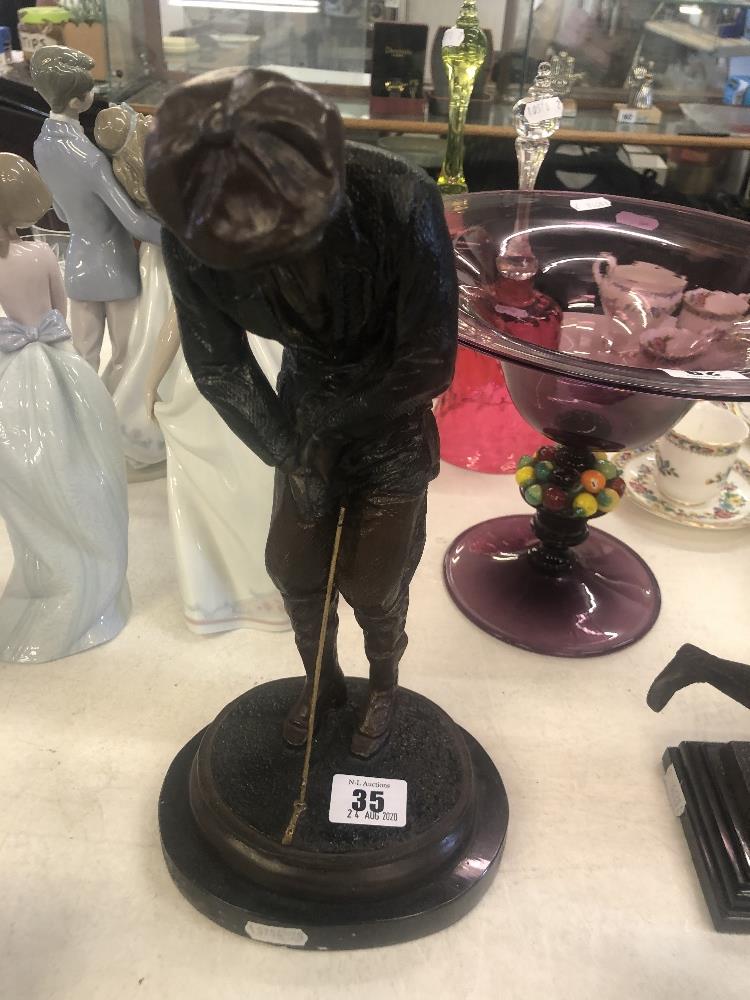 A bronze figure of a golfer