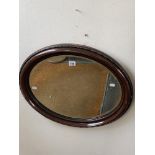 A mahogany oval wall mirror