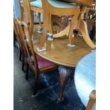 A mahogany extending dining table with extra leaf