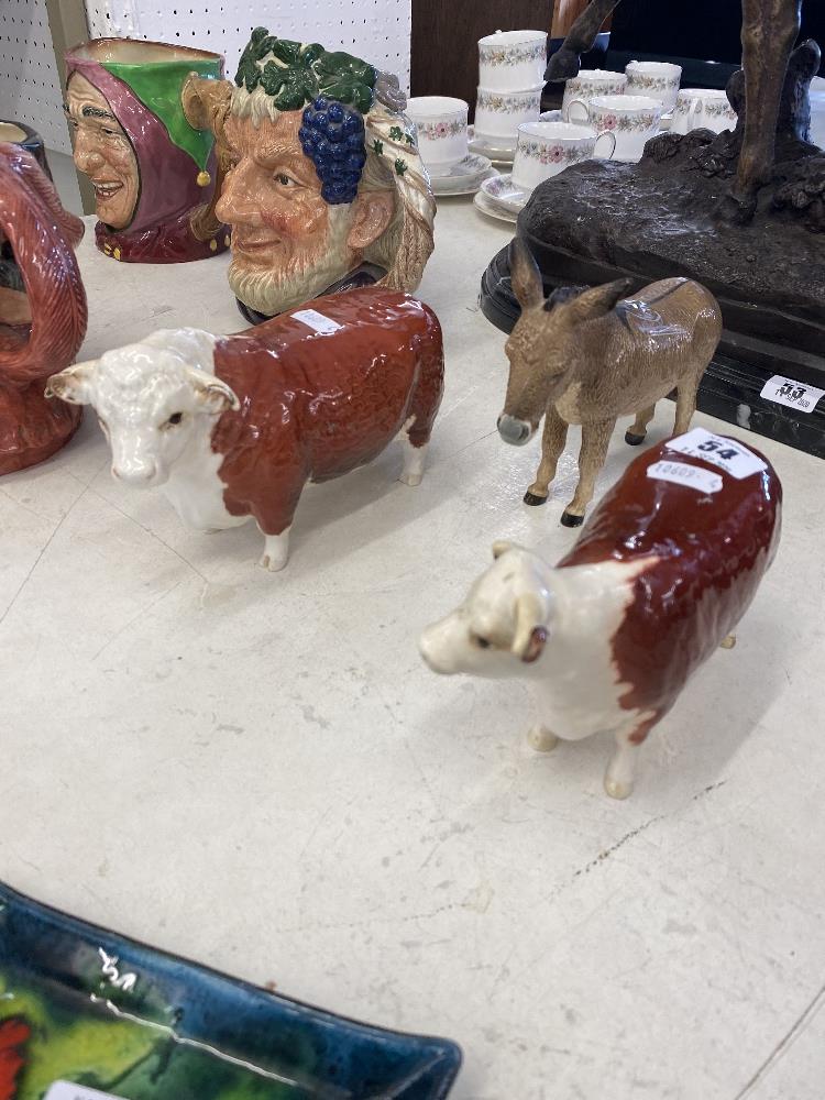 A Beswick donkey and Two Beswick bulls