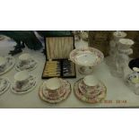 A Coalport cake stand, two teacups, saucers, cake plates and a fish knife set,