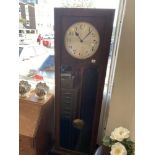 An art deco grandfather clock with pendulum weights and key