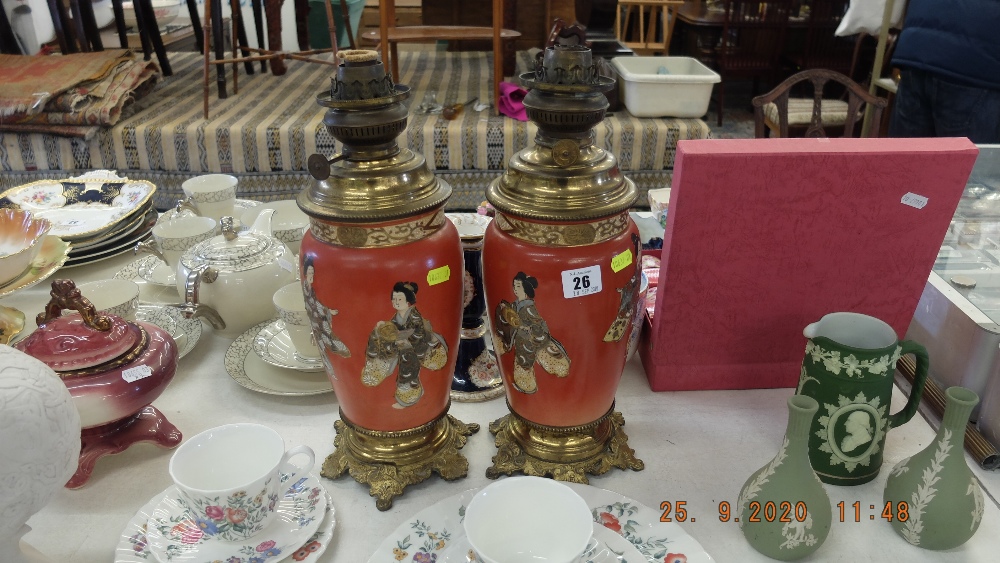 A pair of oil lamps with oriental design to base including shades