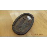 A cast iron ash tray with erotic figures,