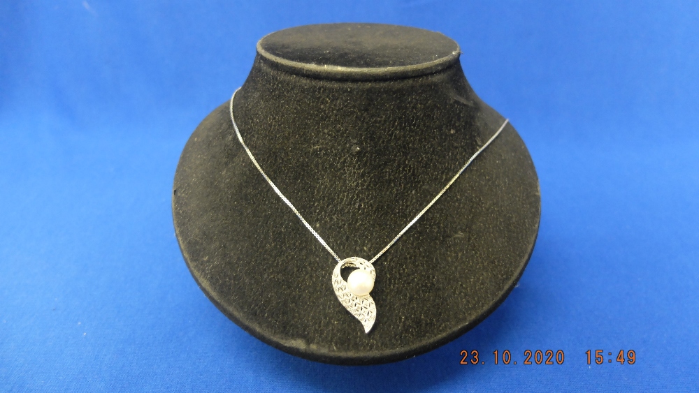 A 9ct white gold diamond pearl set pendant on chain