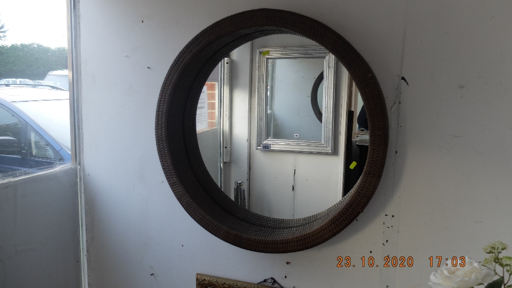 A circular wicker framed mirror