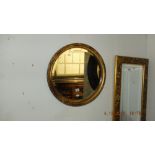 A small circular gilt mirror,
