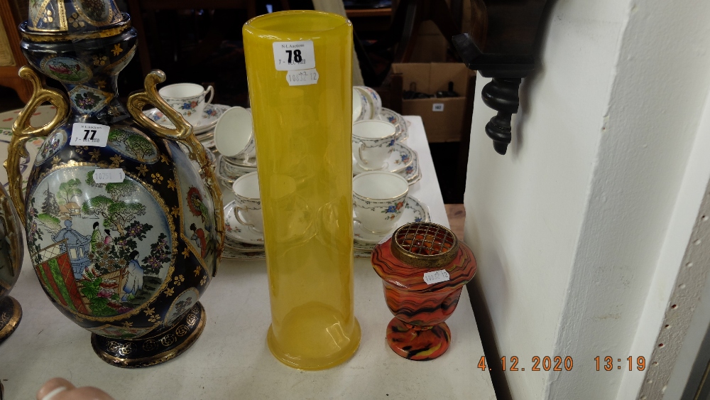 A mustard colour glass vase decorated with flowers