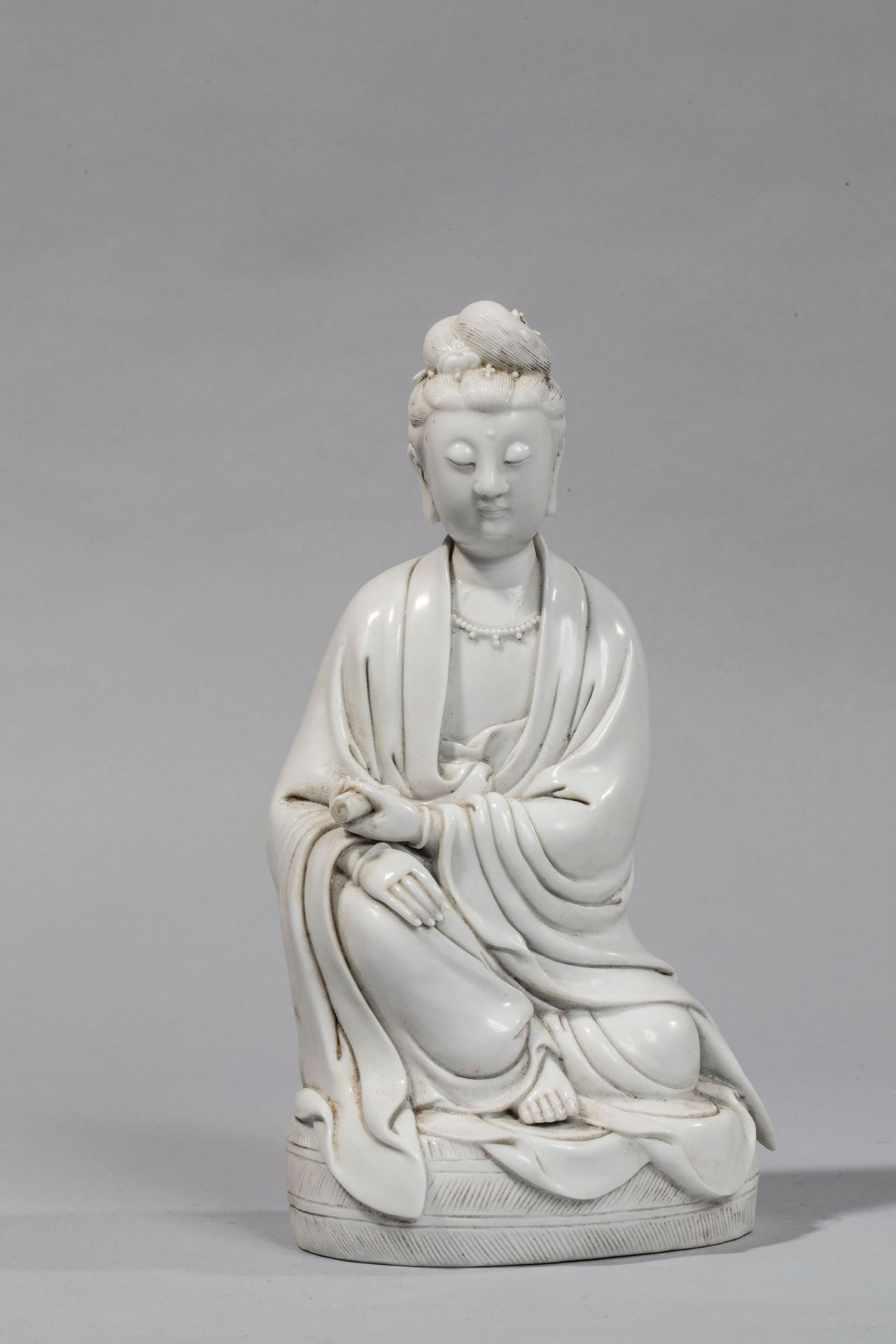 Le Boddhisattva Kwan Yin assis en délassement vêtu de la robe monastique coiffé [...]