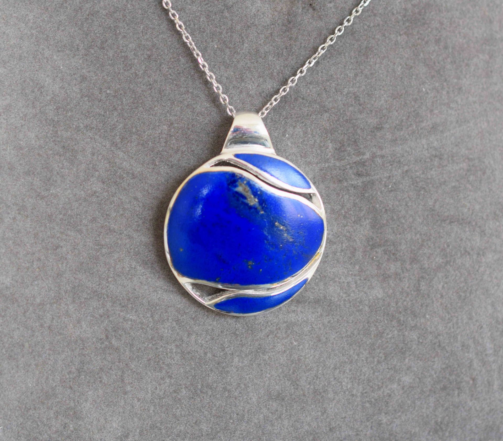 Pendentif argent massif serti en clos d'un lapis lazuli taille stylisée rehaussé [...]