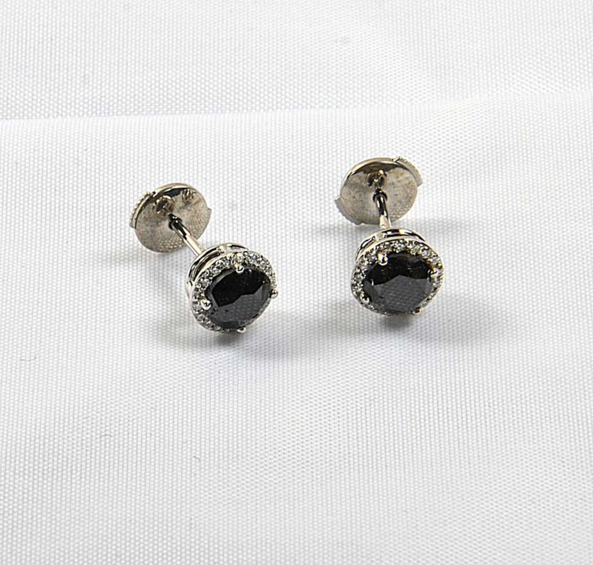 Paire de boucles d'oreilles or blanc centrées de 2 rares diamants noirs pesant [...]