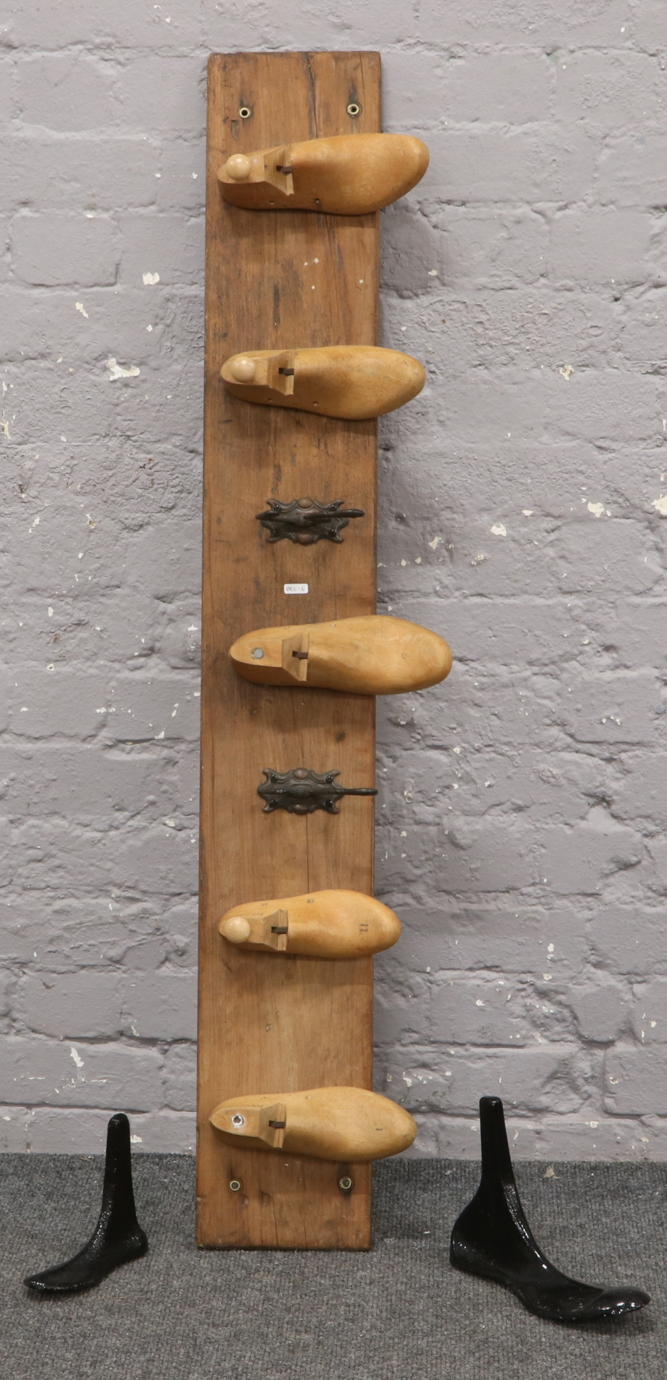 A wooden coat rack with wooden shoe / cast iron hooks.