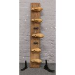 A wooden coat rack with wooden shoe / cast iron hooks.