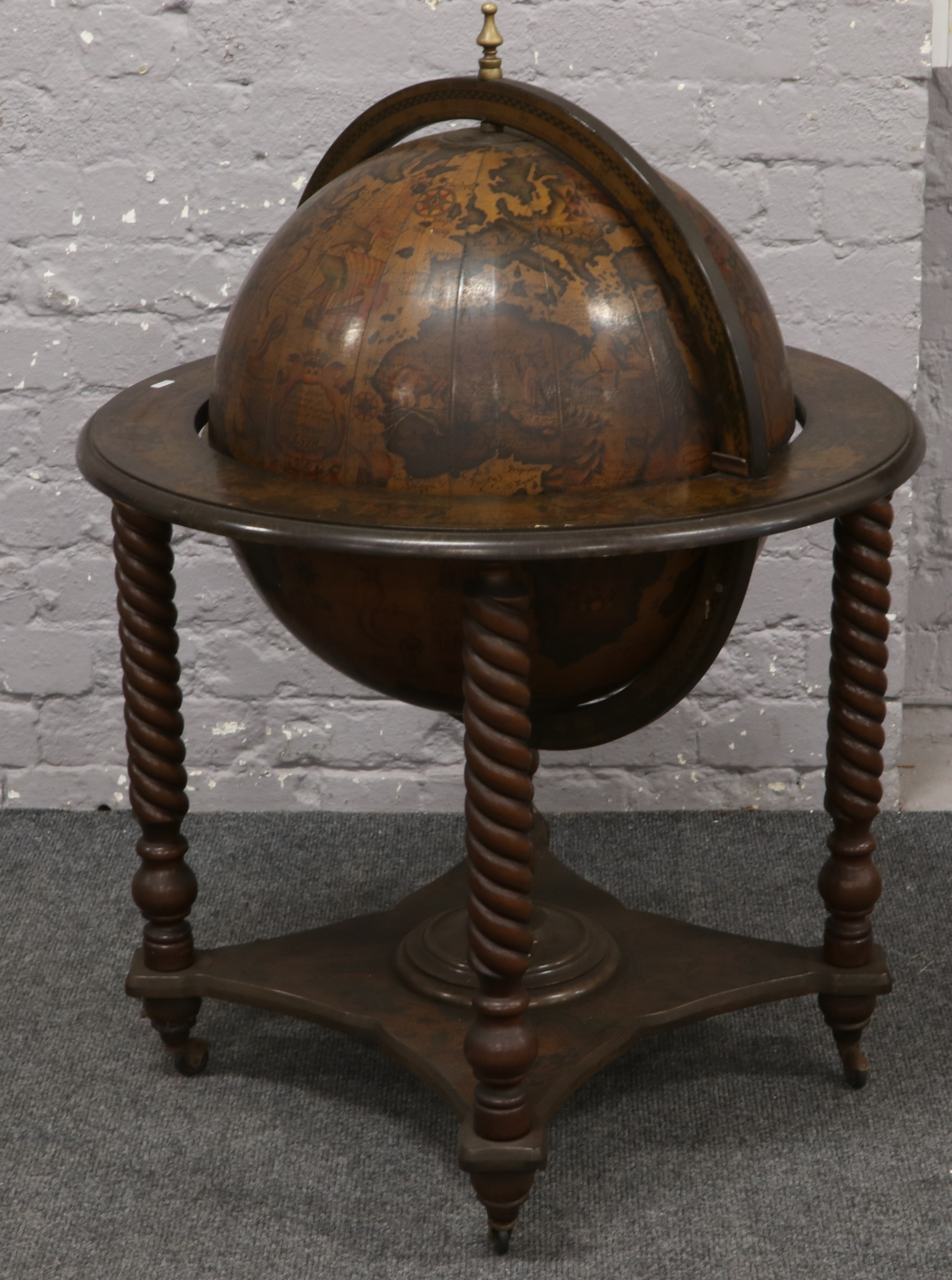 A rotating globe drinks cabinet raised on sugar twist supports, 102cm x 70cm.