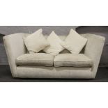 A large high back three seat sofa with cream upholstery.