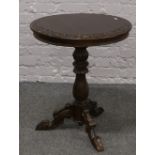 A carved mahogany occasional table raised on extensively carved supports.