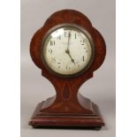 An Edwardian inlaid mahogany balloon mantel clock with cylinder movement and raised on ball feet.