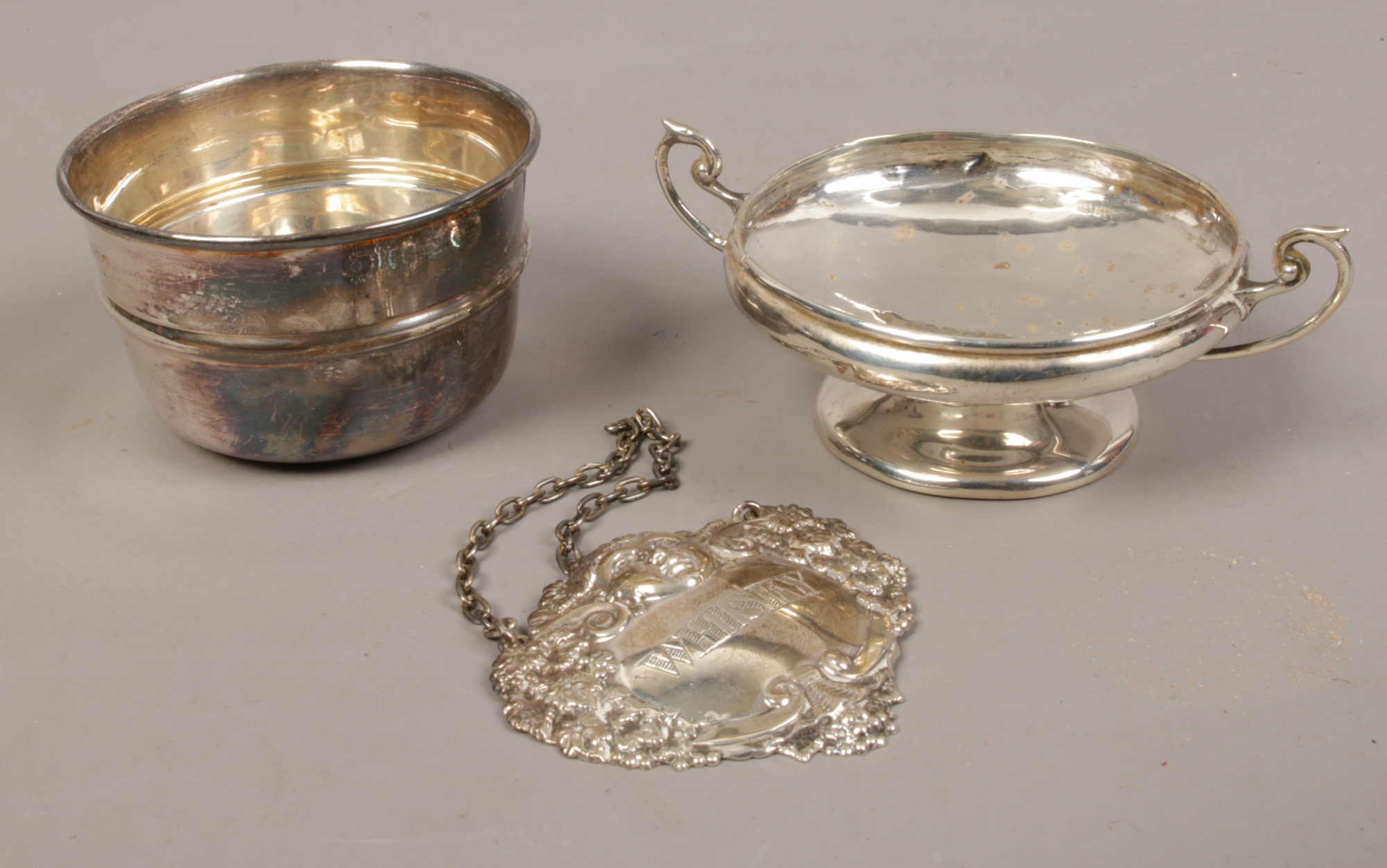 A silver Whisky decanter label along with a silver cup and a miniature comport, 86 grams.