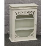 A white painted glass front three shelf bathroom cabinet.
